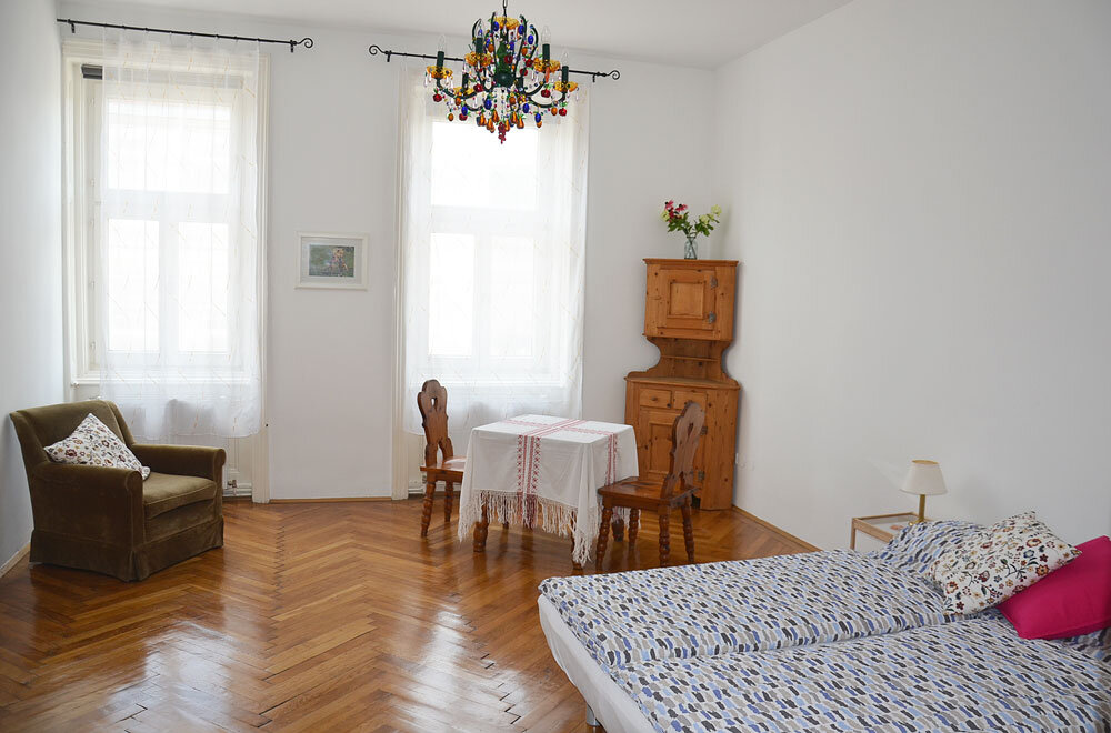 Bright living area with parquet floor & chandelier – 1-room apt for short-term rental in Vienna
