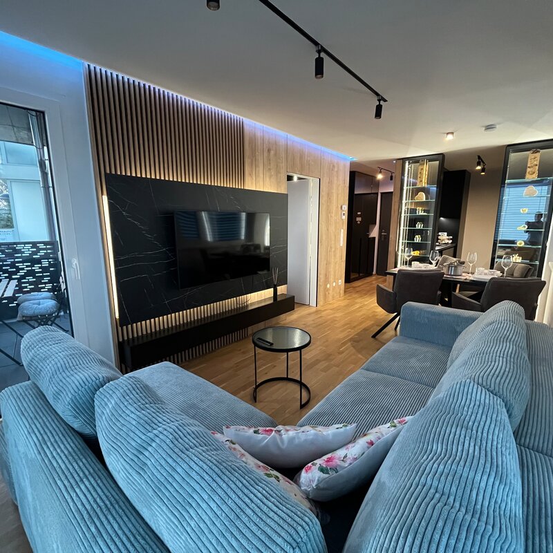 Moderner Wohnbereich mit TV-Wand & Kordel-Sofa – 2-Zimmer-Wohnung zur Kurzzeitmiete in Wien