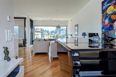 Bright living room with grand piano & panoramic window – 4-room penthouse, short-term rental & temporary housing for 1 to 6 months in Salzburg