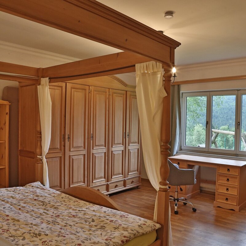Helles Schlafzimmer mit Himmelbett & Holzmöbel – 2-Zimmer Wohnung, Kurzzeitmiete & Wohnen auf Zeit für 1 bis 6 Monate in Bad Aussee
