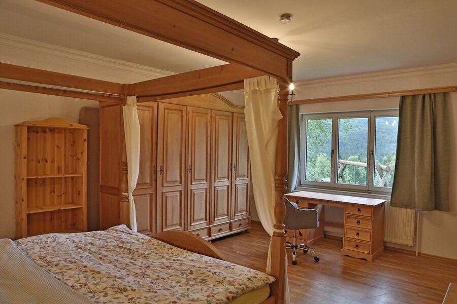 Helles Schlafzimmer mit Himmelbett & Holzmöbel – 2-Zimmer Wohnung, Kurzzeitmiete & Wohnen auf Zeit für 1 bis 6 Monate in Bad Aussee