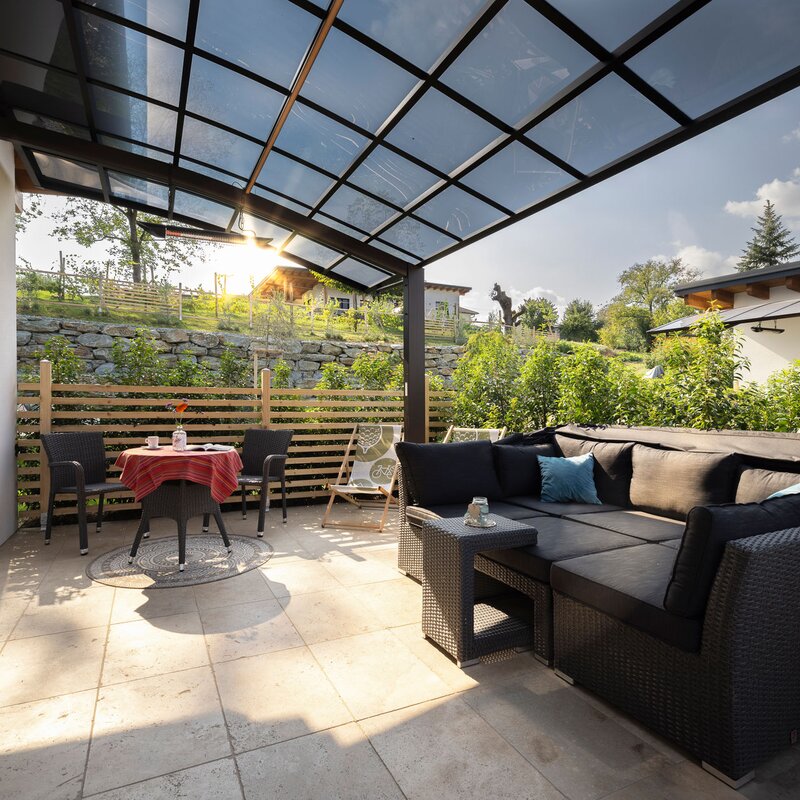 28m2 in Sträucher eingefasster Wohlfühlbereich mit Hochbeet, Sonneninsel, Bistrotisch, Weinfass und Infrarotheizung | © Robert Brünner
