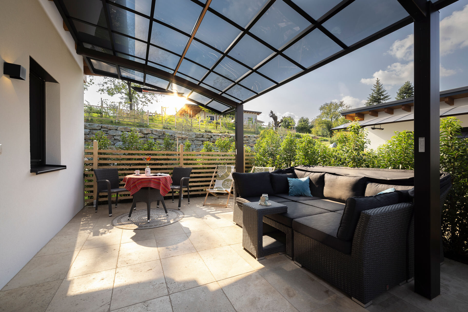 28m2 in Sträucher eingefasster Wohlfühlbereich mit Hochbeet, Sonneninsel, Bistrotisch, Weinfass und Infrarotheizung | © Robert Brünner