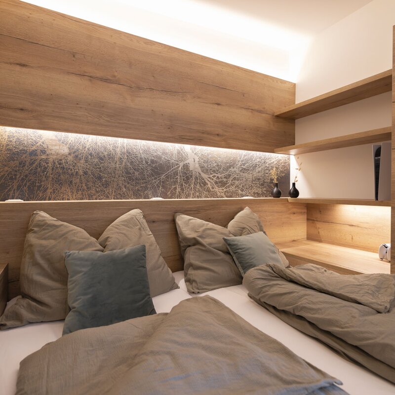 180x200 cm Doppelbett mit Beleuchtung, Büchern, Playstation5 | © Robert Brünner