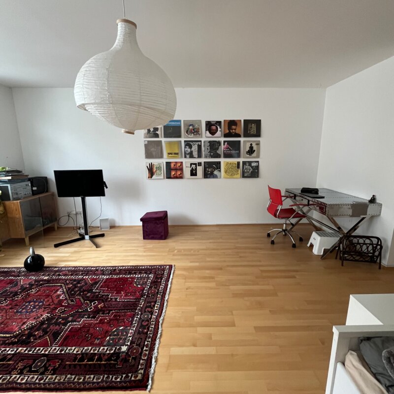 Helles Wohnzimmer mit Parkettboden & Vinylwand – 1-Zimmer Wohnung für Kurzzeitmiete & Wohnen auf Zeit 1 bis 6 Monate in Wien