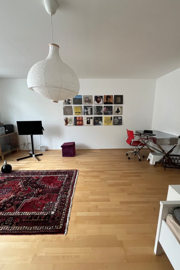 Helles Wohnzimmer mit Parkettboden & Vinylwand – 1-Zimmer Wohnung für Kurzzeitmiete & Wohnen auf Zeit 1 bis 6 Monate in Wien