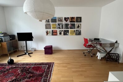 Helles Wohnzimmer mit Parkettboden & Vinylwand – 1-Zimmer Wohnung für Kurzzeitmiete & Wohnen auf Zeit 1 bis 6 Monate in Wien