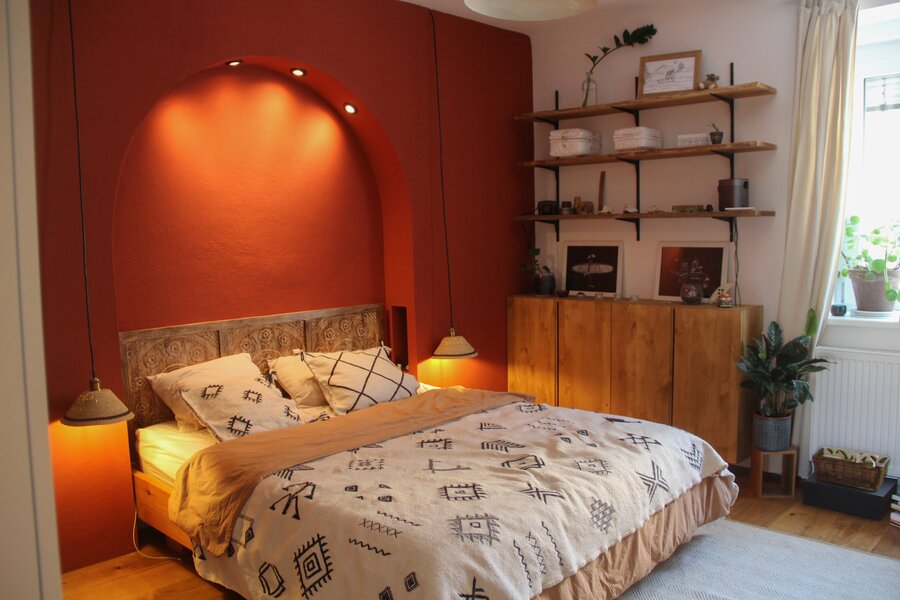 Schlafzimmer mit Doppelbett und Wandregal mit stimmungsvoller Beleuchtung | © ©laurabell
