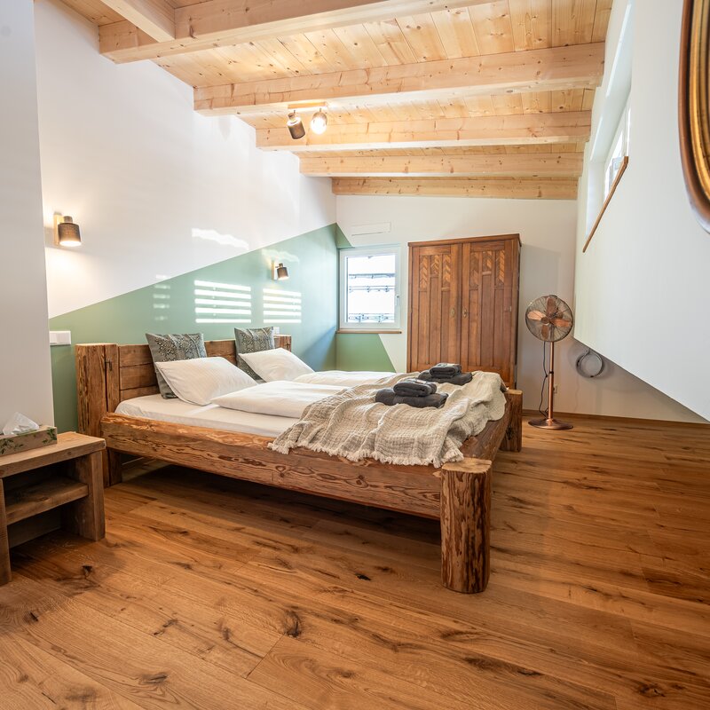 Rustic wood-beam bedroom in 2-room apartment – temporary housing & short-term rental Hallwang, 1 to 6 months