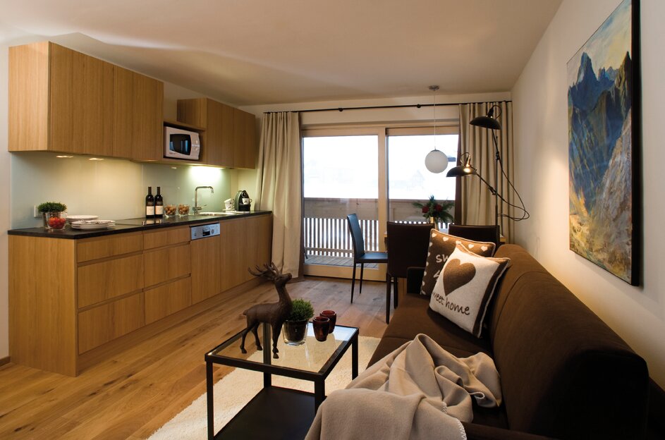 Küchenblock mit Nespresso Kaffee-Maschine, Mikrowelle, Geschirrspüler, Kühlschrank mit Tiefkühlfach, Gläser, Besteck, Geschirr.