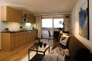 Küchenblock mit Nespresso Kaffee-Maschine, Mikrowelle, Geschirrspüler, Kühlschrank mit Tiefkühlfach, Gläser, Besteck, Geschirr.