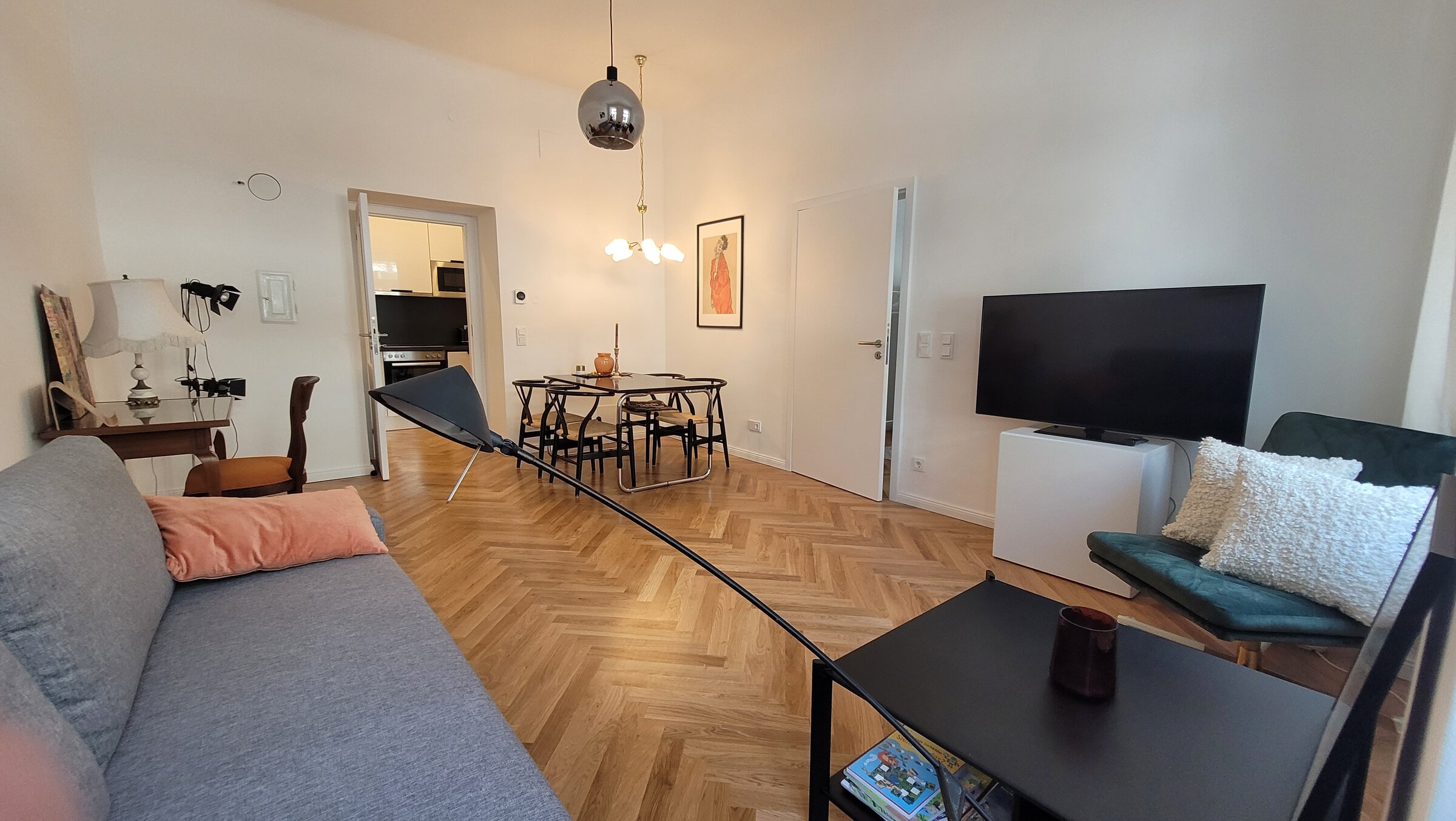 Helles Wohnzimmer mit Fischgrätparkett, Esstisch & TV – 2-Zimmer Wohnung, Kurzzeitmiete Wien, 1–6 Monate
