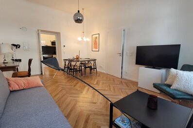 Helles Wohnzimmer mit Fischgrätparkett, Esstisch & TV – 2-Zimmer Wohnung, Kurzzeitmiete Wien, 1–6 Monate