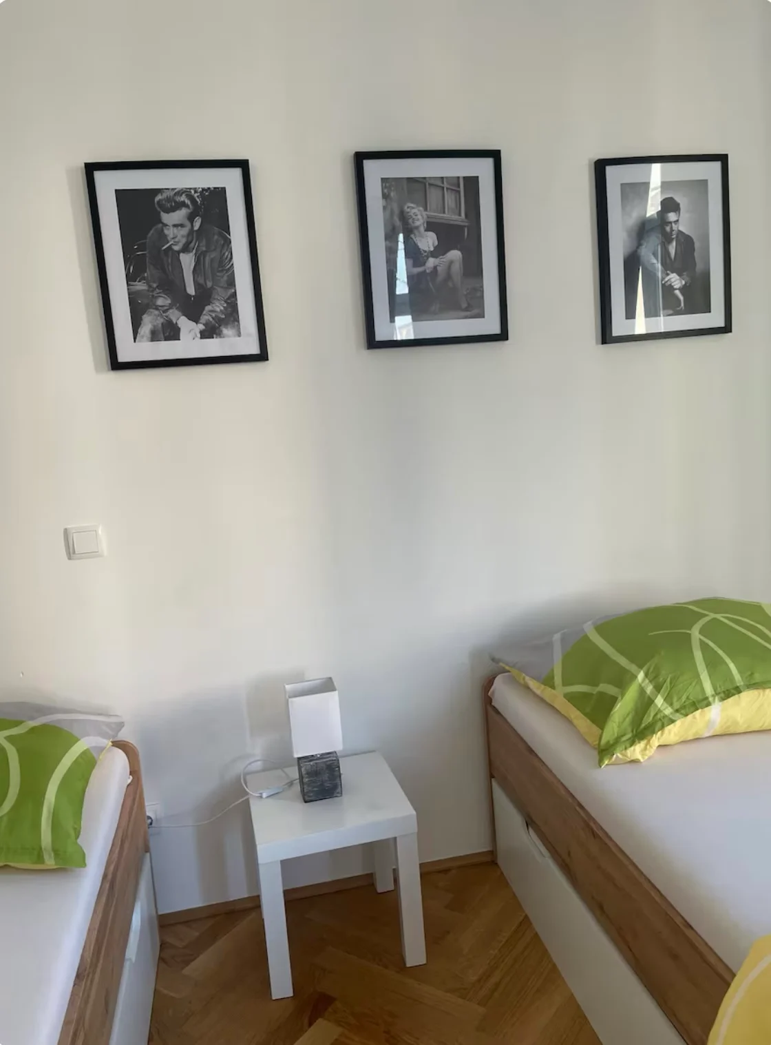 bedroom with two beds, a bedside table, a dresser and two windows