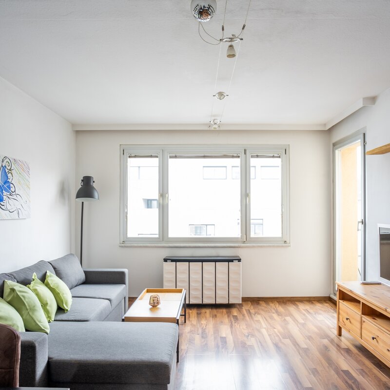 Bright living room with wood floors & sofa – 2-room apartment, short-term rental, temporary housing 1 to 6 months, Vienna