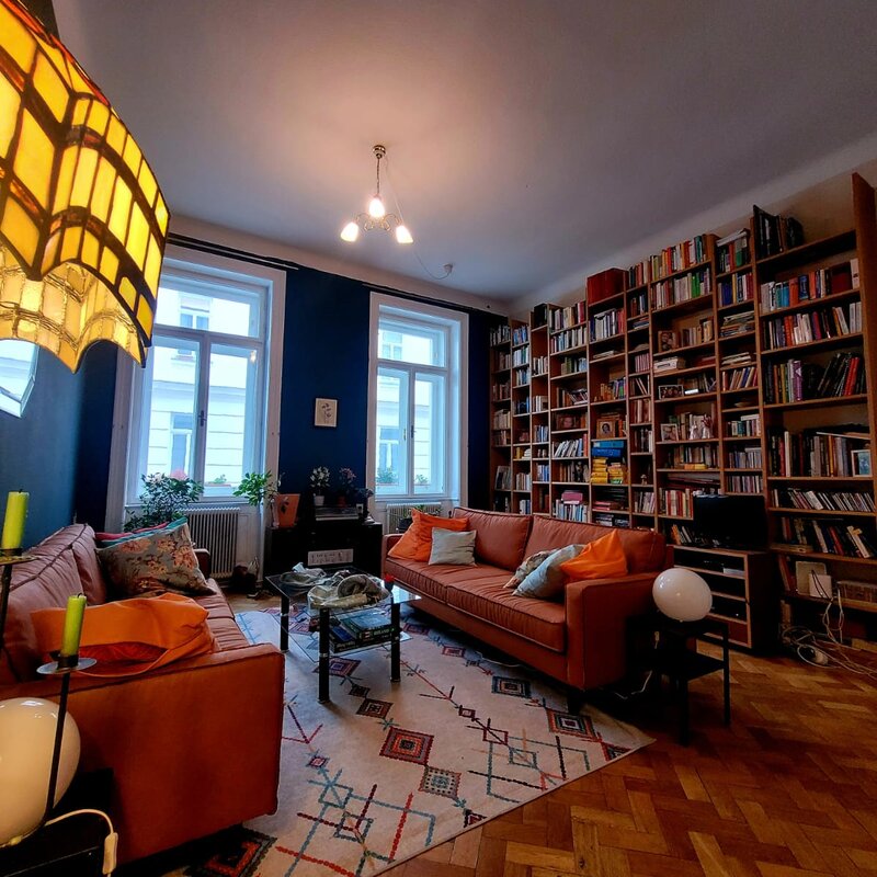 Bright living room with bookshelf & historic charm – 3-room apartment for short-term rental & temporary housing for 1 to 6 months in Vienna