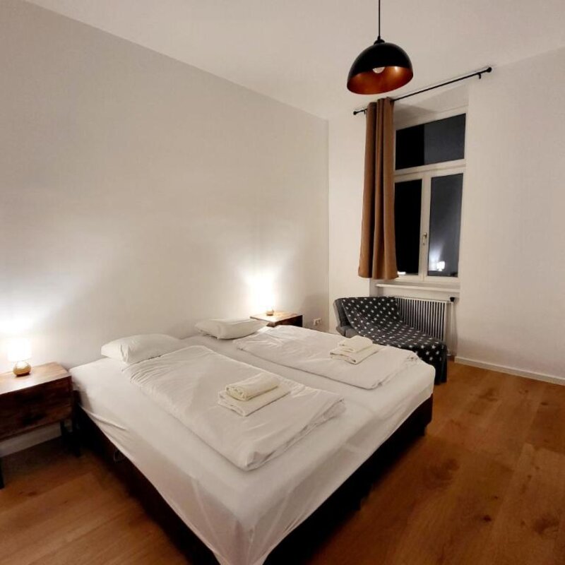 Helles Schlafzimmer mit Doppelbett, Holzboden & modernem Licht – 4-Zimmer Apartment zur Kurzzeitmiete, Wohnen auf Zeit für 1 bis 6 Monate in Wien.