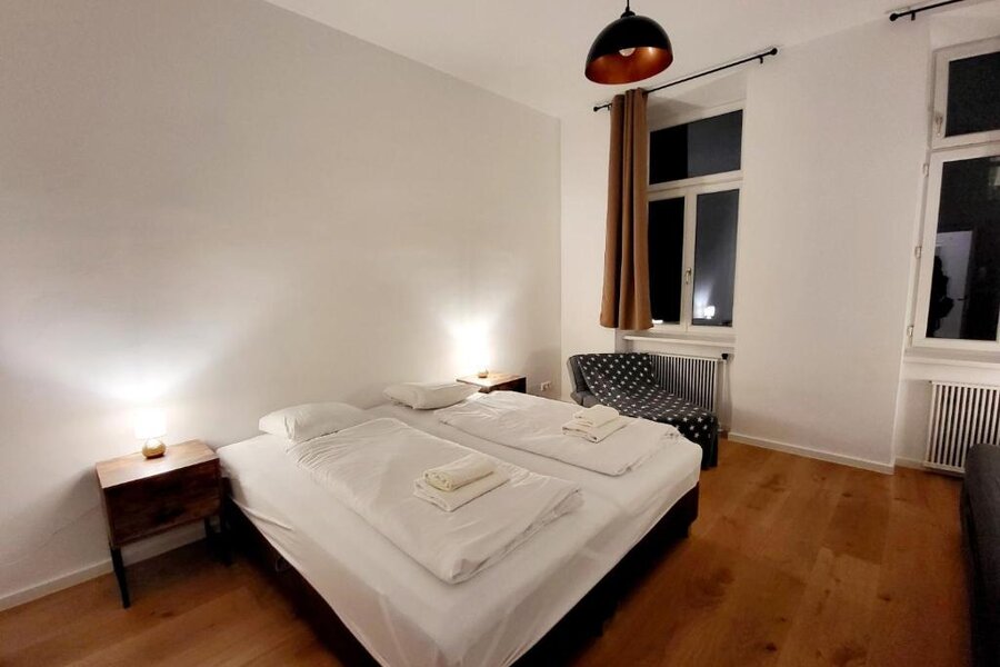 Helles Schlafzimmer mit Doppelbett, Holzboden & modernem Licht – 4-Zimmer Apartment zur Kurzzeitmiete, Wohnen auf Zeit für 1 bis 6 Monate in Wien.