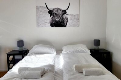 Helles Schlafzimmer mit Doppelbett & Deko – 1-Zimmer Apartment zur Kurzzeitmiete & Wohnen auf Zeit für 1 bis 6 Monate in Wien