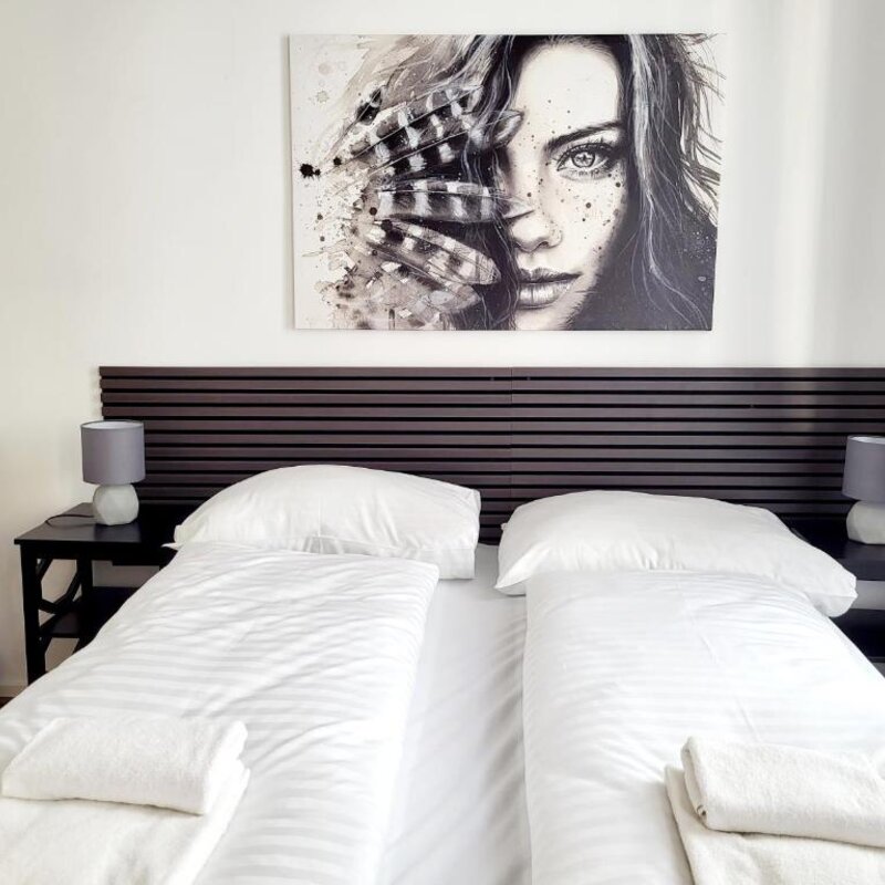 Helles Schlafzimmer mit Doppelbett & Wandkunst – 2-Zimmer-Wohnung, Kurzzeitmiete & Wohnen auf Zeit für 1 bis 6 Monate in Wien