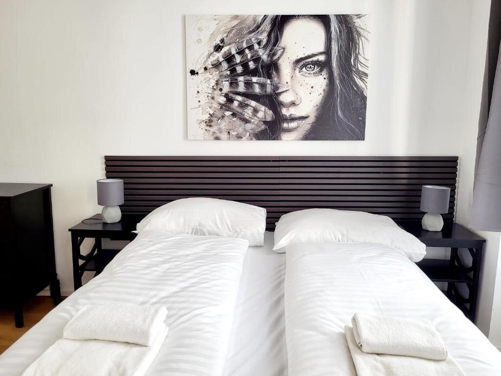 Helles Schlafzimmer mit Doppelbett & Wandkunst – 2-Zimmer-Wohnung, Kurzzeitmiete & Wohnen auf Zeit für 1 bis 6 Monate in Wien
