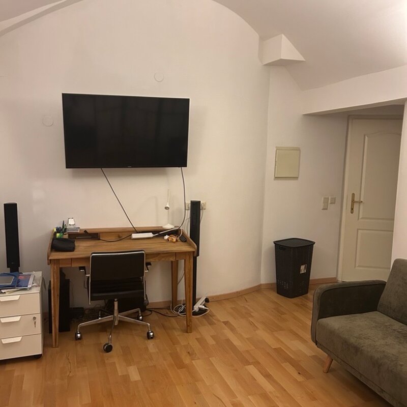 Stylisches Wohn- und Arbeitszimmer mit Flachbildschirm, Designer Schreibtisch und gemütlicher Couch 