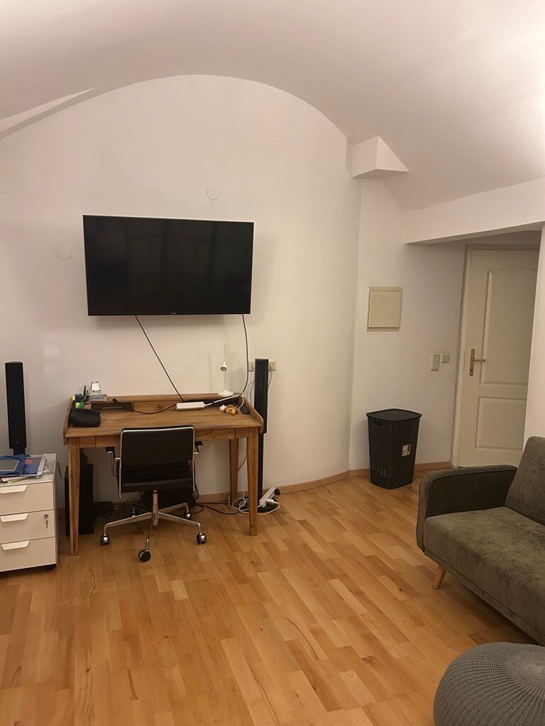 Stylisches Wohn- und Arbeitszimmer mit Flachbildschirm, Designer Schreibtisch und gemütlicher Couch 