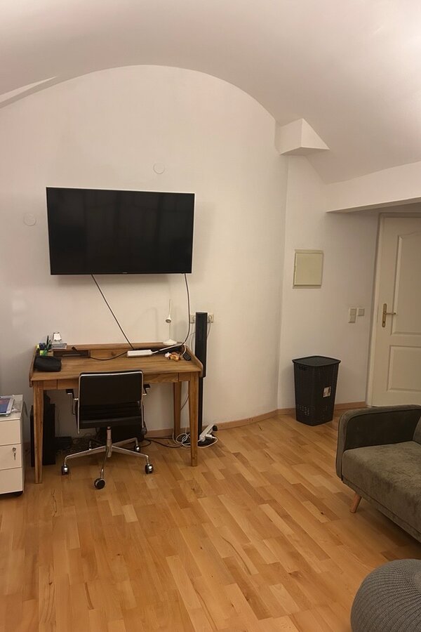 Stylisches Wohn- und Arbeitszimmer mit Flachbildschirm, Designer Schreibtisch und gemütlicher Couch 