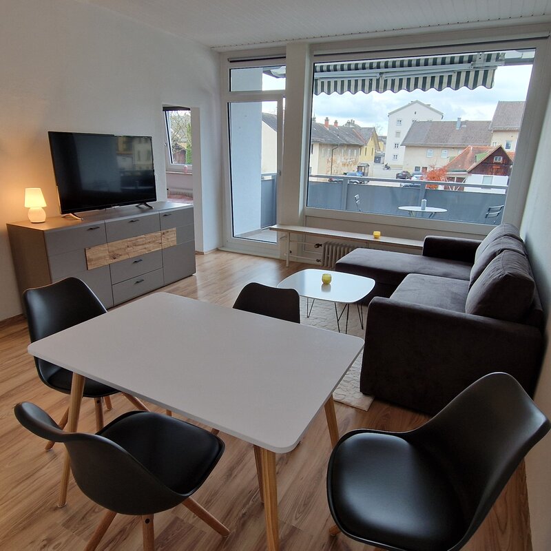 Bright living area with dining table & balcony – 2-room apartment, short-term rental & temporary housing for 1 to 6 months in Freilassing