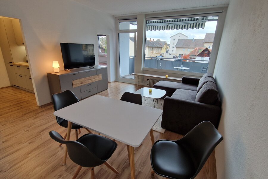 Bright living area with dining table & balcony – 2-room apartment, short-term rental & temporary housing for 1 to 6 months in Freilassing