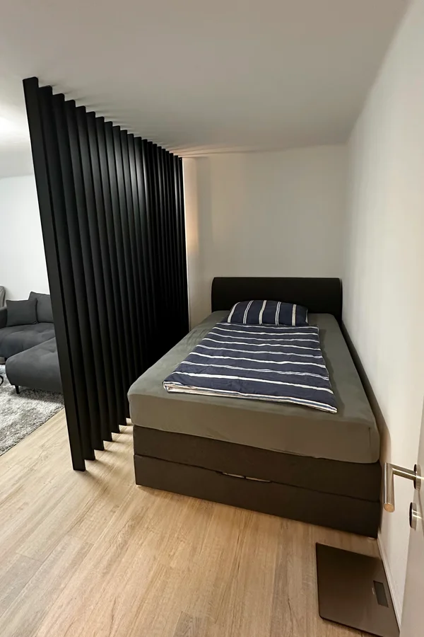 Die charmante Schlafnische mit komfortablen Bett und stimmiger Beleuchtung - ein ruhiger Rückzugsort zum Erholen.