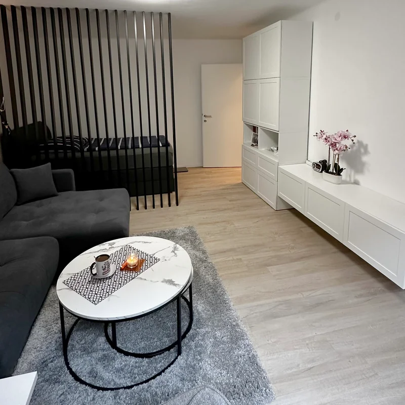 Das frisch renovierte Wohnzimmer mit moderner Couch, stilvollen Möbeln und viel Tageslicht - perfekt zum Entspannen nach einem langen Tag.