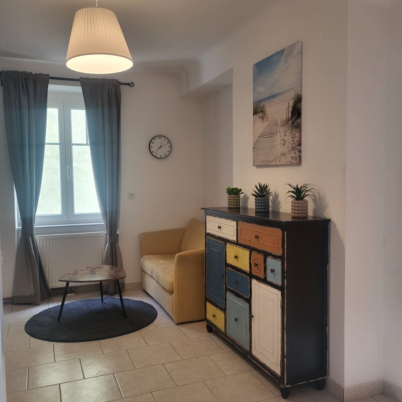 Bright living room with colorful sideboard & sofa – 2-room apartment, short-term rental Melk, temporary housing 1 to 6 months