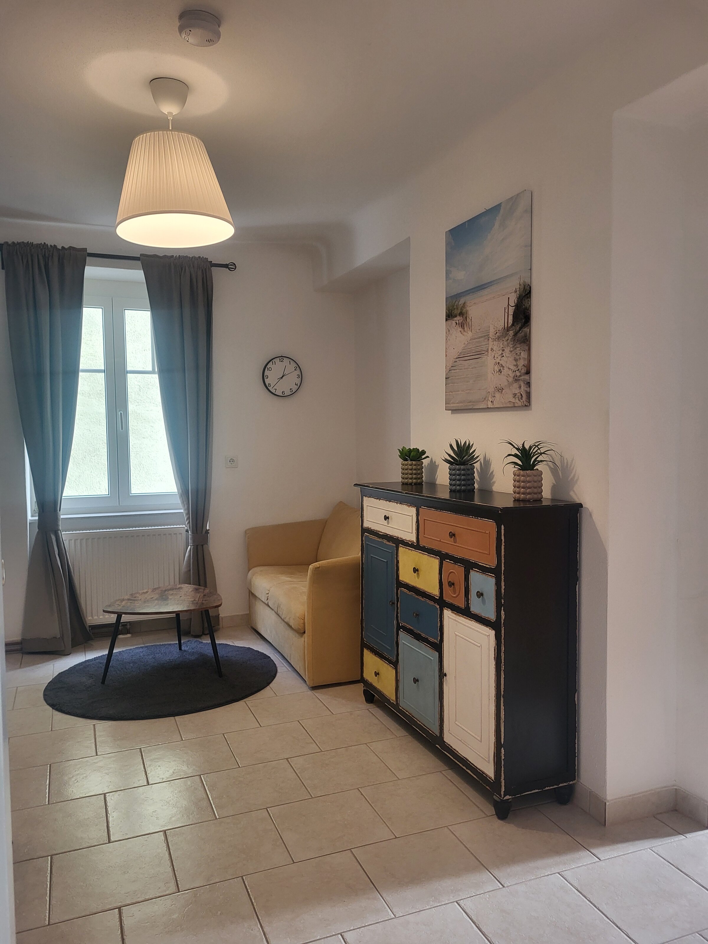 Bright living room with colorful sideboard & sofa – 2-room apartment, short-term rental Melk, temporary housing 1 to 6 months