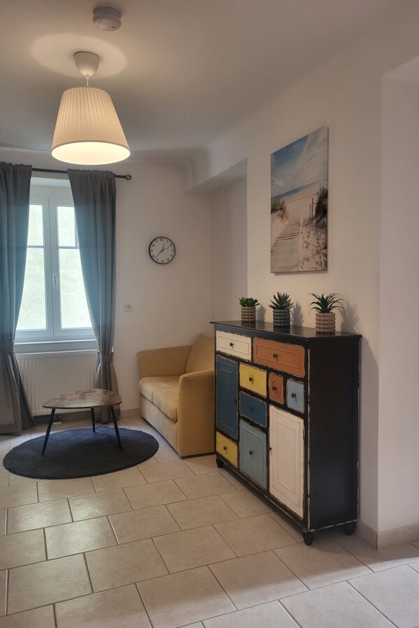 Bright living room with colorful sideboard & sofa – 2-room apartment, short-term rental Melk, temporary housing 1 to 6 months