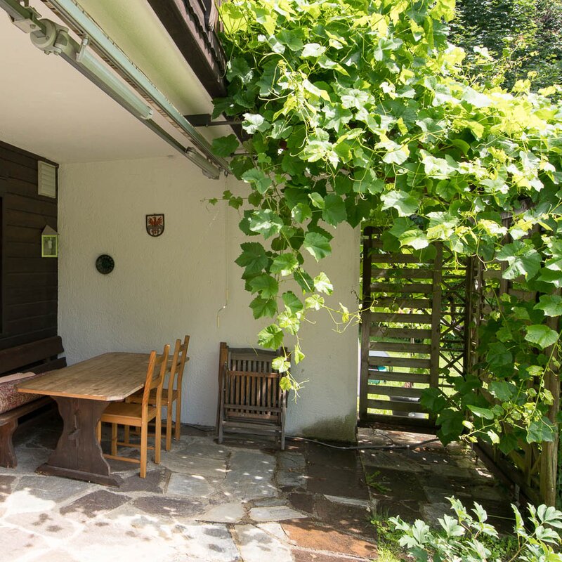 Terrace with wooden furniture & vine – 3-room apartment for short-term rental & temporary housing for 1 to 6 months in Volders