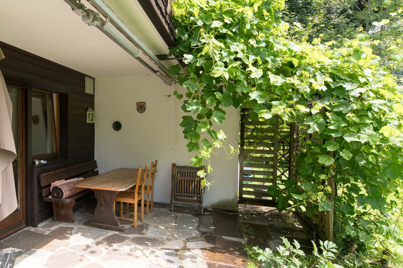 Terrace with wooden furniture & vine – 3-room apartment for short-term rental & temporary housing for 1 to 6 months in Volders