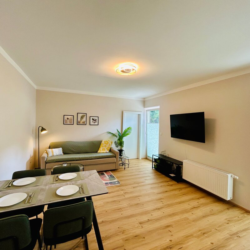 Helles Wohn-Esszimmer mit TV & Sofa – 2-Zimmer Wohnung zur Kurzzeitmiete in Hof bei Salzburg, 1–6 Monate