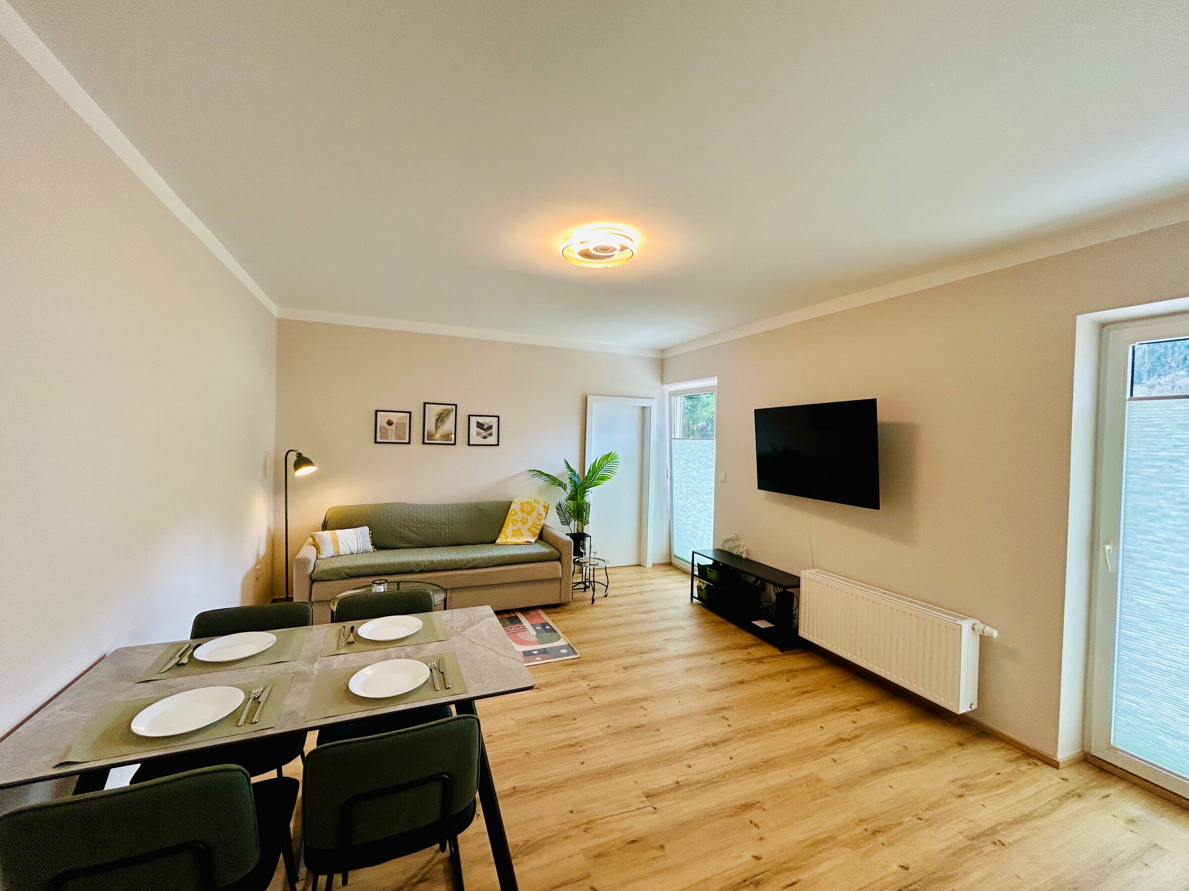 Helles Wohn-Esszimmer mit TV & Sofa – 2-Zimmer Wohnung zur Kurzzeitmiete in Hof bei Salzburg, 1–6 Monate