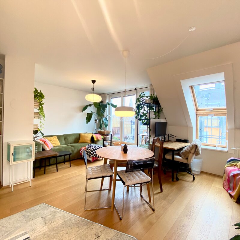 Helles Wohnzimmer mit Holzboden & Pflanzen – 2-Zimmer Wohnung zur Kurzzeitmiete, Wohnen auf Zeit für 1 bis 6 Monate in Wien