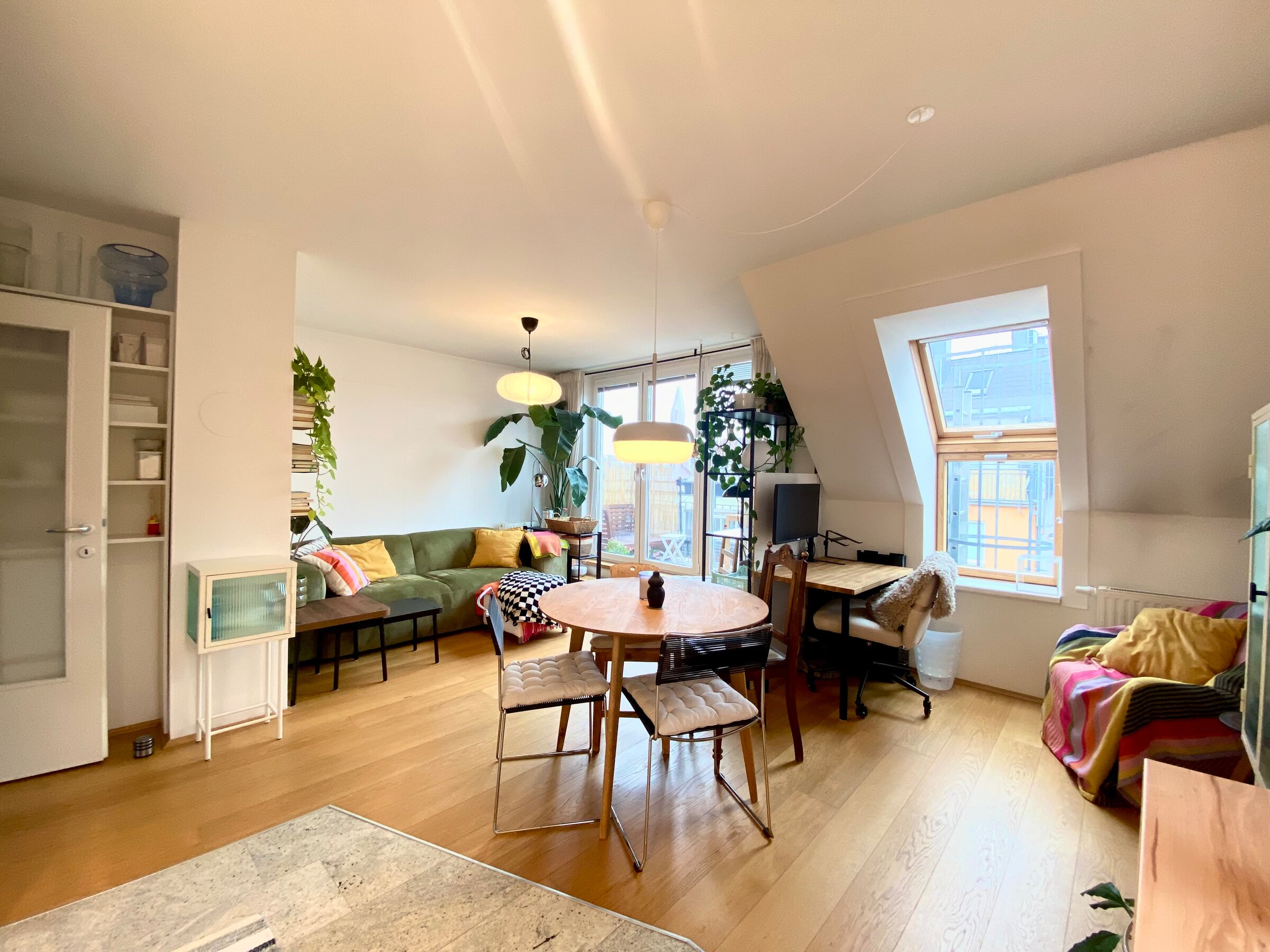 Helles Wohnzimmer mit Holzboden & Pflanzen – 2-Zimmer Wohnung zur Kurzzeitmiete, Wohnen auf Zeit für 1 bis 6 Monate in Wien