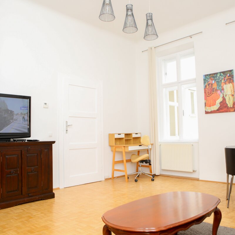 Helles Wohnzimmer mit Arbeitsplatz und Essbereich – stilvoll und gemütlich im Herzen Wiens | © Heikel Ben Bouzid