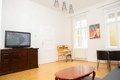 Helles Wohnzimmer mit Arbeitsplatz und Essbereich – stilvoll und gemütlich im Herzen Wiens | © Heikel Ben Bouzid