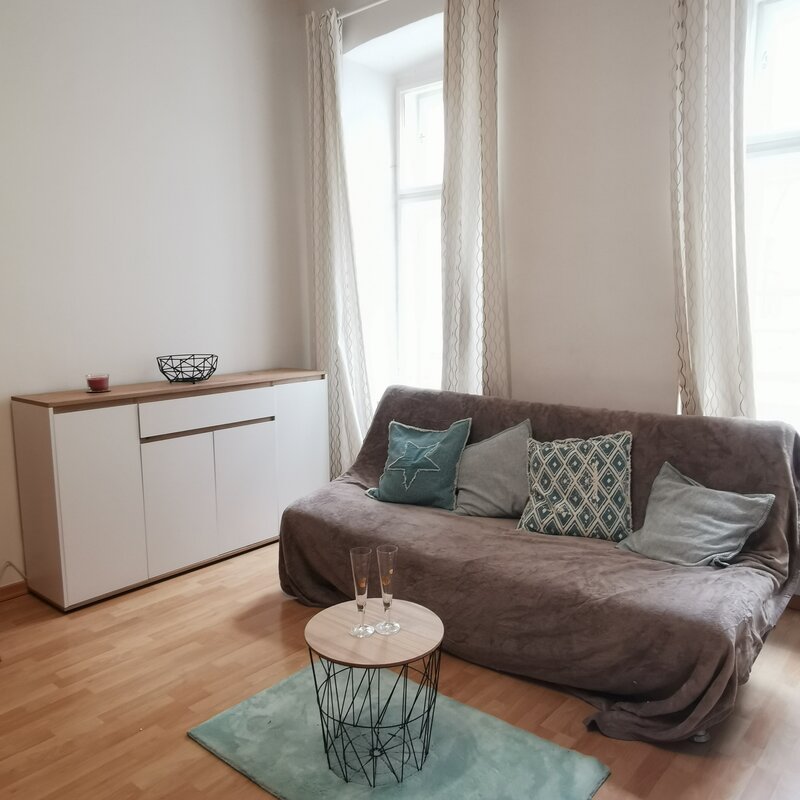 Helles Wohnzimmer mit Sofa & modernem Sideboard – 1-Zimmer Apartment zur Kurzzeitmiete, Wohnen auf Zeit 1 bis 6 Monate, Wien