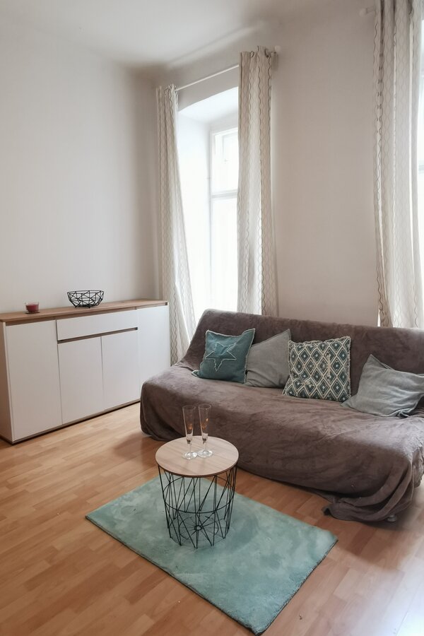 Helles Wohnzimmer mit Sofa & modernem Sideboard – 1-Zimmer Apartment zur Kurzzeitmiete, Wohnen auf Zeit 1 bis 6 Monate, Wien