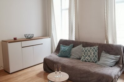 Helles Wohnzimmer mit Sofa & modernem Sideboard – 1-Zimmer Apartment zur Kurzzeitmiete, Wohnen auf Zeit 1 bis 6 Monate, Wien