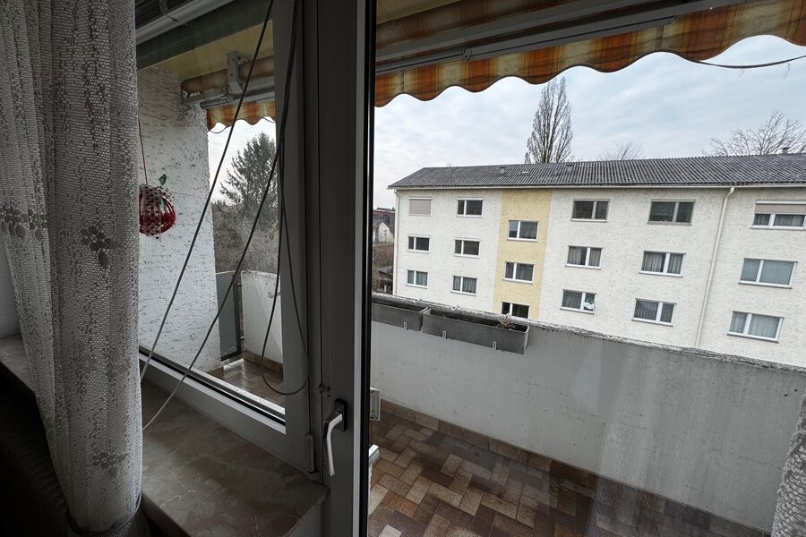Die 6 m² große Loggia bietet einen schönen Ausblick auf die umliegenden Wohnhäuser und Grünflächen. Große Fenster lassen viel Tageslicht in die Wohnung. Ein Sonnenschutz-Markise sorgt für angenehmen Schatten an heißen Tagen. Die Loggia ist ideal zum Entspannen und bietet zusätzlichen Wohnraum im Freien. | © Stefan Gabriel