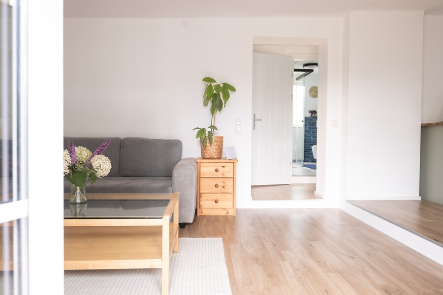 View through the living area and the hallway to the bathroom. Patio door at the back.