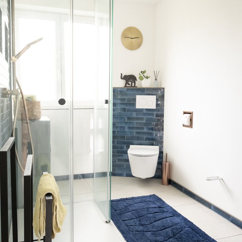 Blue tiles and bronze fittings give the modern bathroom a special ambience.