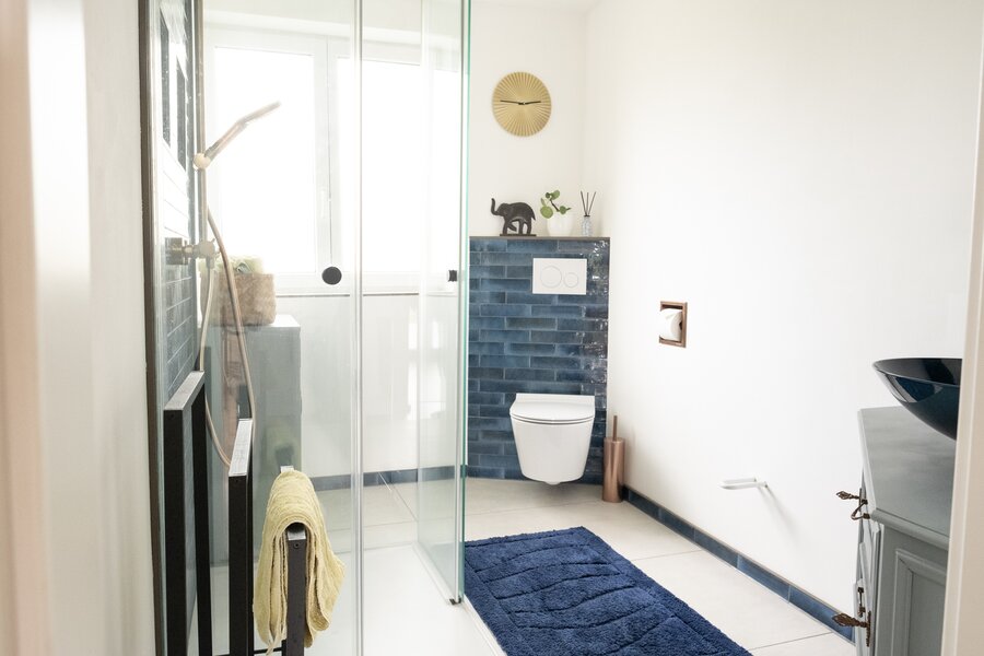 Blue tiles and bronze fittings give the modern bathroom a special ambience.
